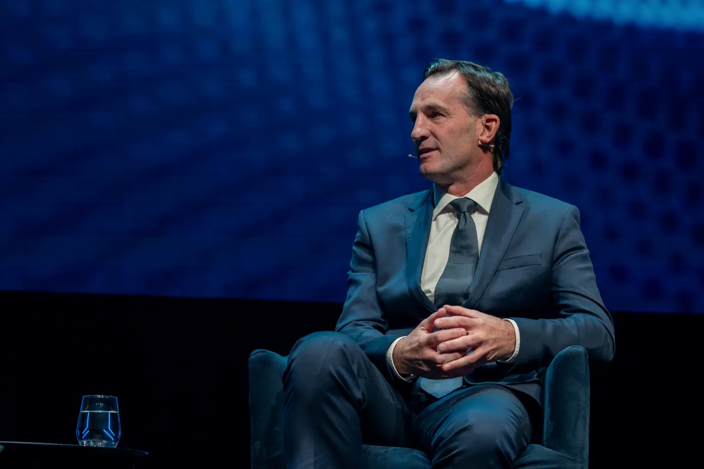 A speaker seated on stage at SportNXT